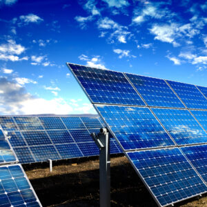 Rows of photovoltaic solar panels and blue sky with clouds